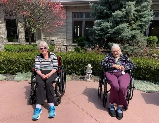 Two senior women in wheelchairs smiling